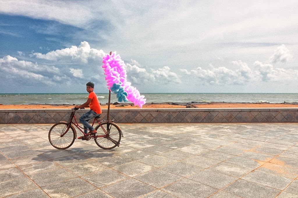 A boy cycling beside Promenade in Pondicherry and selling cotton candy