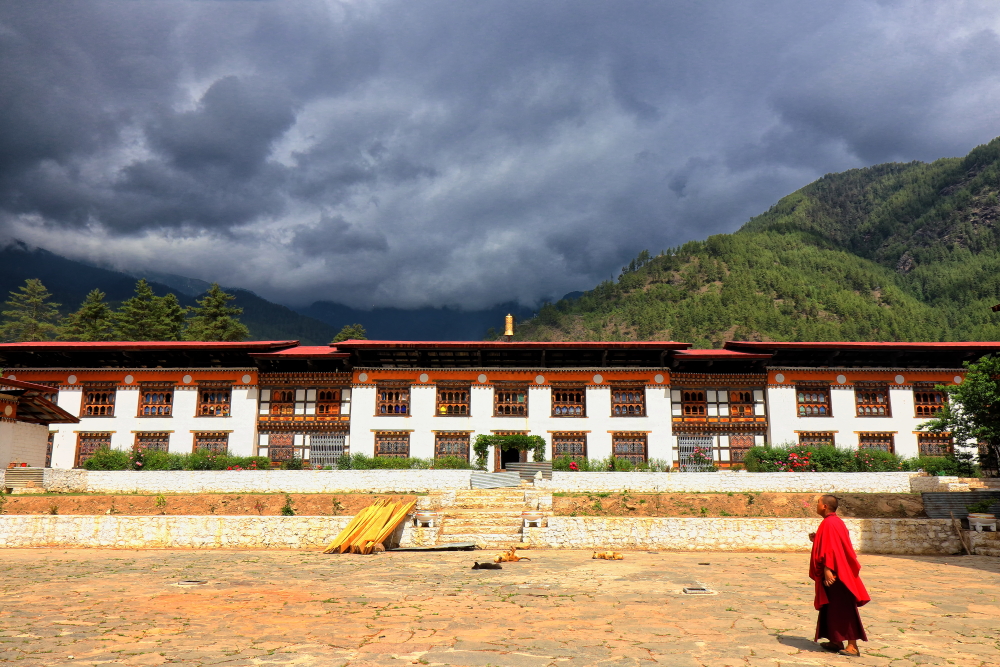 Image of a monk looking at monsoon sky inside Pangri Zampa Monastery