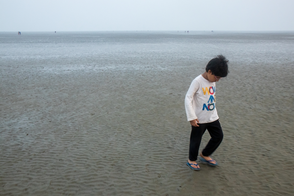 My son busy in spotting a marine life in Chandipur sea beach