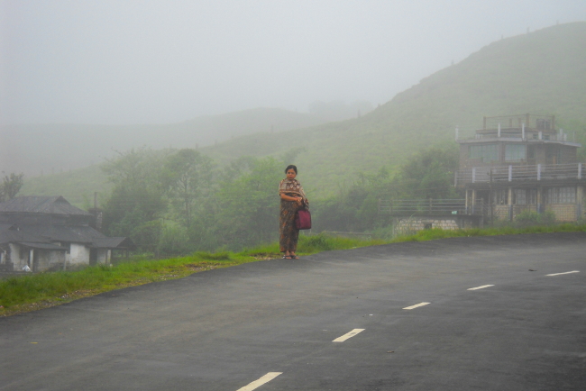 A woman waiting for transport in Cherrapunjee, India